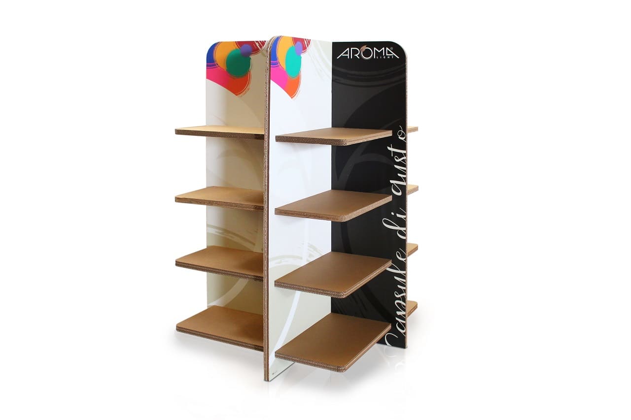 Présentoir en carton écologique pour l’aménagement de magasins, avec étagères modulables et supports personnalisables. Structure solide en panneaux cartonnés renforcés, idéale pour exposer des produits ou organiser des espaces commerciaux, incluant un panneau imprimé avec logo 'Aroma' et texte 'Consultez notre catalogue' - Le Meuble en Carton une marque du groupe Natur Design