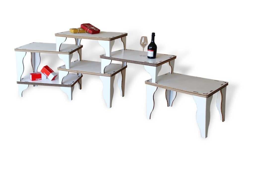 Présentoirs modulables en carton blanc pour stands événementiels et décoration de magasins, avec plateaux décorés d'éléments visuels comme bouteilles et produits exposés, idéaux pour l'aménagement de salons professionnels ou espaces commerciaux - Le Meuble en Carton une marque du groupe Natur Design