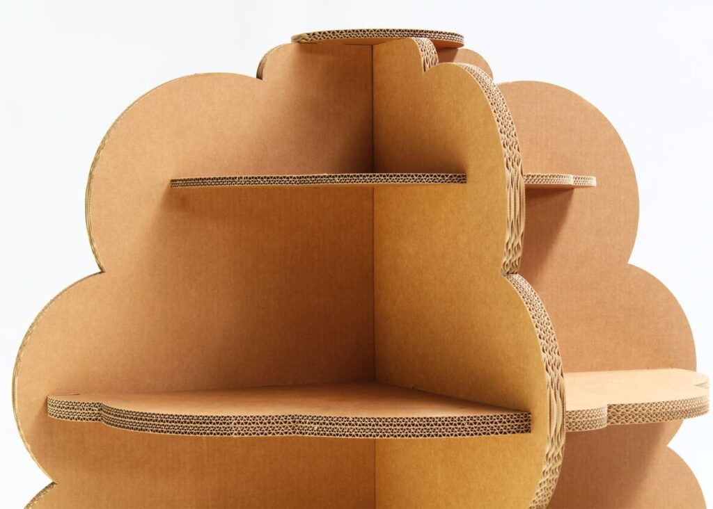 Présentoir en carton KAILA, design organique pour l'aménagement de magasins : structure modulable avec plateaux inclinables et compartiments décoratifs en carton recyclé, idéal pour la mise en valeur visuelle des produits dans les espaces commerciaux - Le Meuble en Carton une marque du groupe Natur Design
