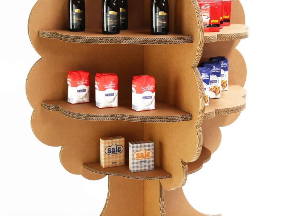 Présentoir en carton KAILA pour l'aménagement de magasins, structuré en forme d'arbre avec étagères décoratives en carton ondulé, affichant des produits alimentaires (bouteilles de vin, sachets de céréales, boîtes de conserve et articles promotionnels) organisés de manière esthétique et fonctionnelle pour la présentation commerciale en magasin - Le Meuble en Carton une marque du groupe Natur Design
